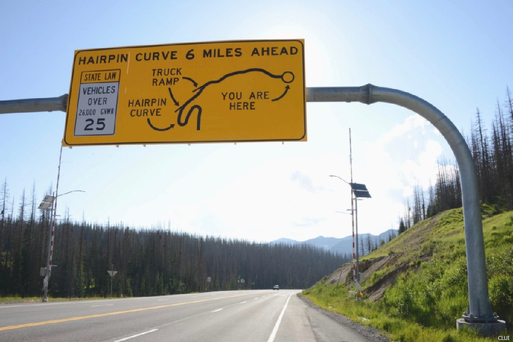 overhead highway sign on Wolf Creek Pass Colorado for hairpin curves ahead