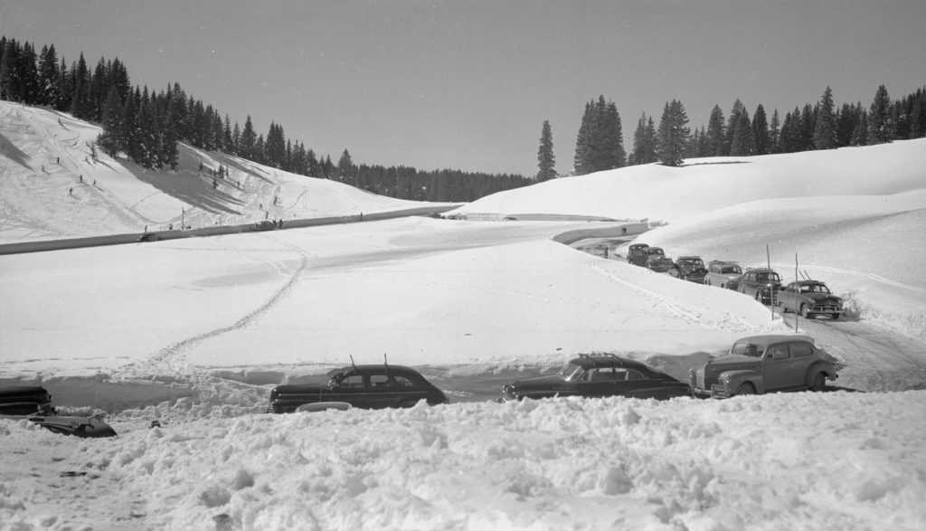 Historical photo from 1950 on top of Wolf Creek Pass with rope tow and highway and parking with old cars